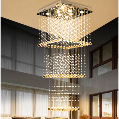 Modern chandelier hanging from a ceiling in a room with large windows.